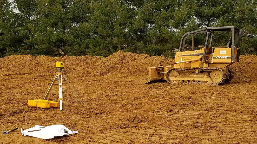 dirt job site with survey equipment and bulldozer